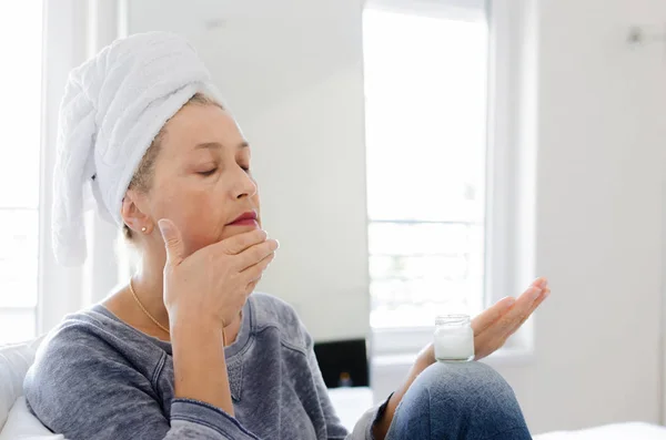 Senior Woman Putting Cream Face Home — Stock Photo, Image