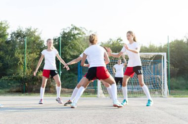 Young female handball players are playing defence in game, outside. clipart