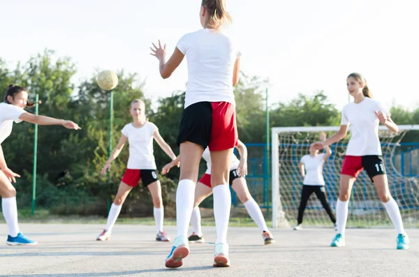 Young female handball players are playing match outside.