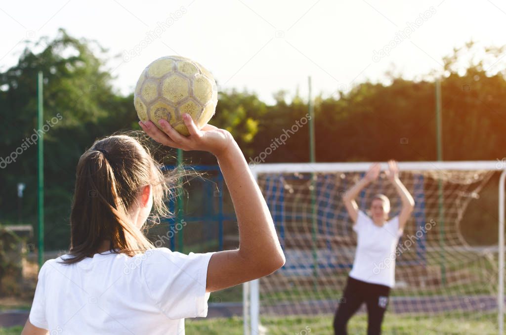 Handball players are playing game outside.