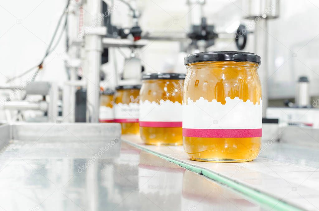 Image of jar full with organic honey, production in factory. Space for text.