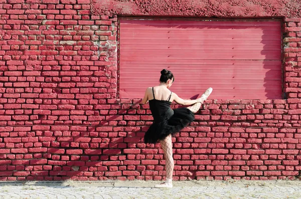 Vista Traseira Dançarina Ballet Feminina Estendendo Frente Parede Tijolo Vermelho — Fotografia de Stock