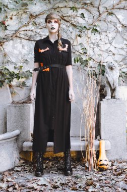 Siyah ve turuncu makyaj ile genç esmer kadın içinde Halloween kılık giyinmiş