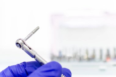 diş hekimi diş aleti elinde tutan