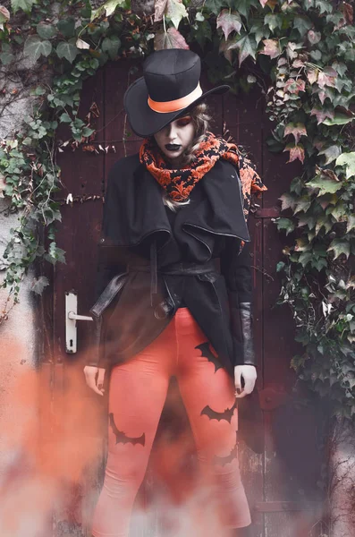 ハロウィーンの黒とオレンジの衣装を着た若い女性のフロント ビュー — ストック写真