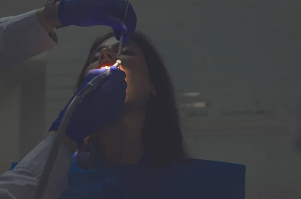 歯科医は彼女の歯を研磨で若いメスの患者の肖像 — ストック写真