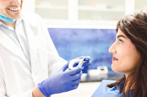 Закрыть портрет пациентки, посещающей стоматолога для отбеливания зубов в клинике
