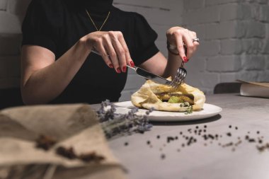 Restoran sebzeli ızgara sandviç yeme kadında görünümünü kırpılmış