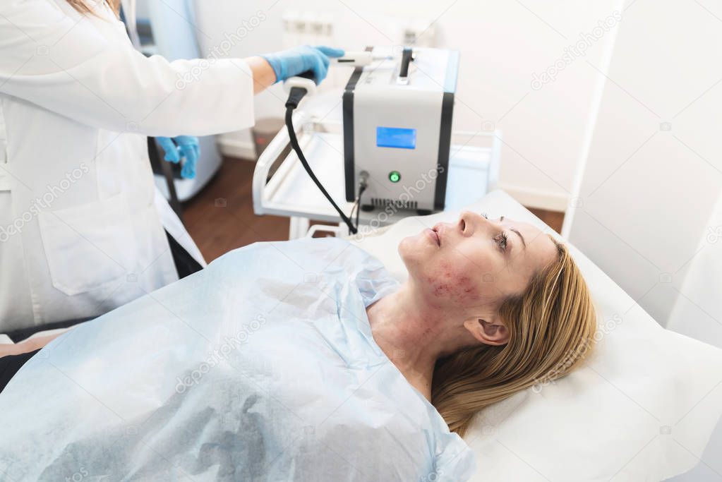 Adult blonde woman lying on bad at beauty clinic