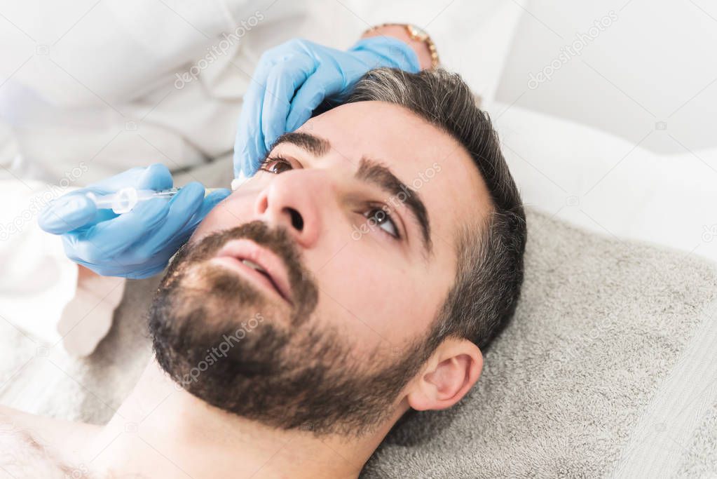 Close up of young man having hyaluronic fillers in his face