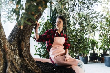 Genç kadın bahçıvan Bahçe stetoskop ile sağlıklı ağaç denetimi 