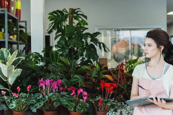 Penjual Bunga Wanita Muda Profesional Menuliskan Pesanan Klien — Stok Foto