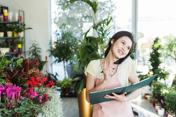 Portrait Young Female Florist Talking Phone Making Notes Flower Shop — Stok Foto