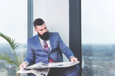 Kendine güvenen modern patron ofisine pencere gazete okuma sakallı