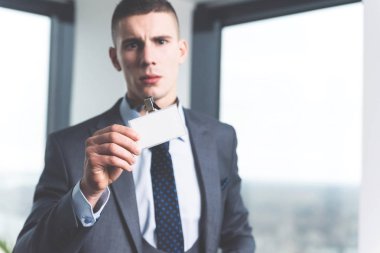 Modern ofis plastik onun kimlik kartı gösteren genç hırslı çalışkan Yöneticisi