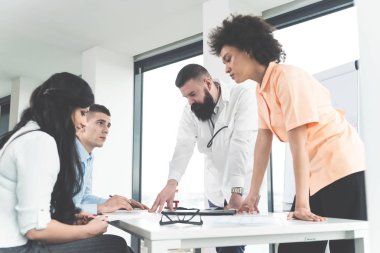 Genç evli çift profesyonel doğurganlık uzmanları ile in vitro fertilizasyon yöntemi ve prosedür hakkında tartışıyor