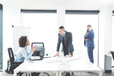 Erkek arkadaşlarıyla sohbet ve office penceresinde tarafından ayakta iken masada oturan kadın