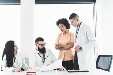 Hasta tanı ve tedavisi hakkında tıbbi uygulama özel toplantıda üzerinde tartışırken genç iddialı profesyonel hekimlerin