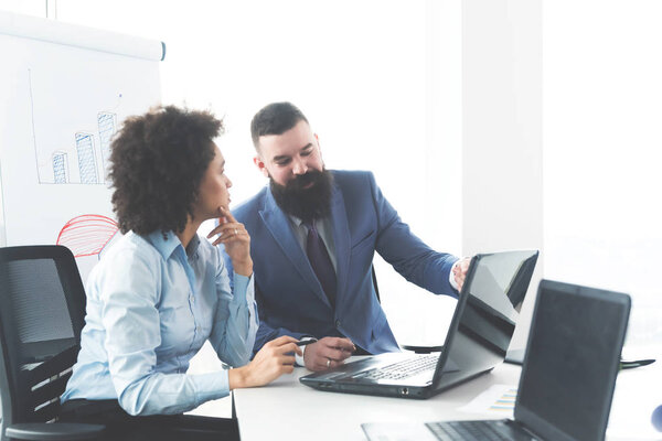 Коллеги работают вместе над проектом в ярком современном офисе
