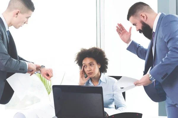 Frustrated depressed young business woman and her colleagues at modern office