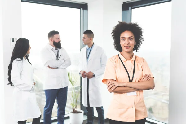 stock image Multicultural team of young professional doctors posing in bright modern private medical practice