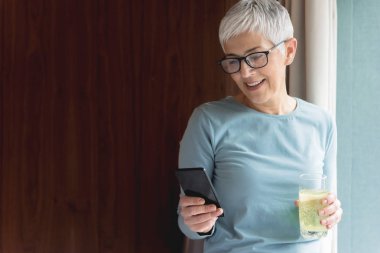 Cep telefonu metin mesajları okuma modern kısa gri saçlı güzel olgun kadın