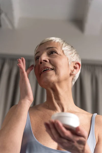 Gorgeous Nourished Mature Woman Short Hair Applying Face Cream Her — Stock Photo, Image