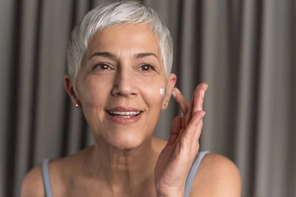 Gorgeous Nourished Mature Woman Short Hair Applying Face Cream Her — Stock Photo, Image