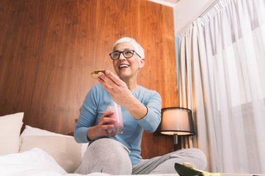 Avokado, besleyici vejeteryan yemek konsepti ile sağlıklı ekmek yeme gözlüklü güzel Olgun kadın