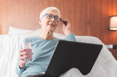 Güzel Olgun kadın evde onun laptop, hafta sonu vibes ve serbest zaman kavramı ile soğutma 