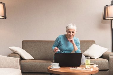 Onu laptop evde, online iş kavramı çalışan üst düzey kadın