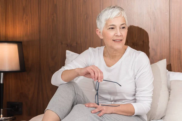 Fröhliche Seniorin Mit Großem Schönen Lächeln Sitzt Auf Bequemem Bett — Stockfoto