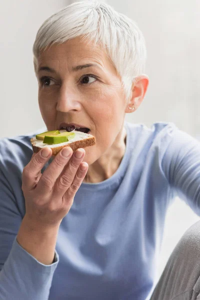 健康栄養価の高い新鮮な菜食主義者とアボカド トーストを食べて 美しい熟女の肖像 — ストック写真