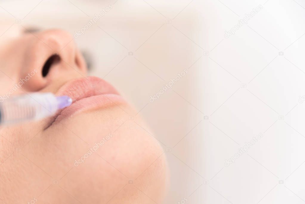 Close up of female lips injected with medical substance with syringe