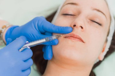 Hastaların dudak hyaluron enjekte doktorlar ellerin yakın