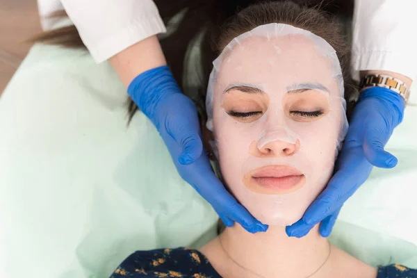 Entspannte Schöne Junge Frau Mit Feuchtigkeitsspendender Gesichtsmaske Schönheitssalon — Stockfoto