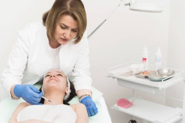 Mezoterapi anti-aging cilt bakımı tedavisi yapan kendine güvenen konsantre kozmetolojist ön görünümü 