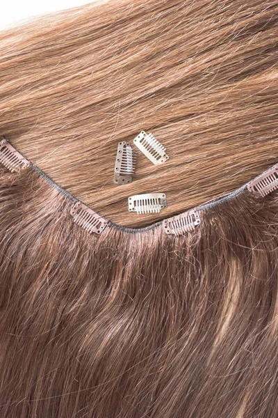Close up of brown hair extension with clips on it
