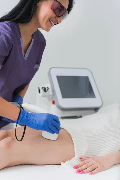 Cosmetologist doing upper leg hair removal laser treatment on female patient — Stock Image Cosmetologist Doing Upper Leg Hair Removal Laser Treatment Female Patient Stock Picture