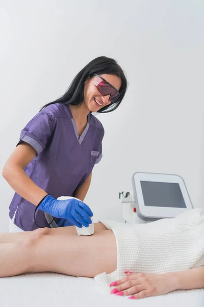 Cosmetologist doing hair removal laser treatment on patients thigh — Stock Image Cosmetologist Doing Hair Removal Laser Treatment Patients Thigh Royalty Free Stock Photos