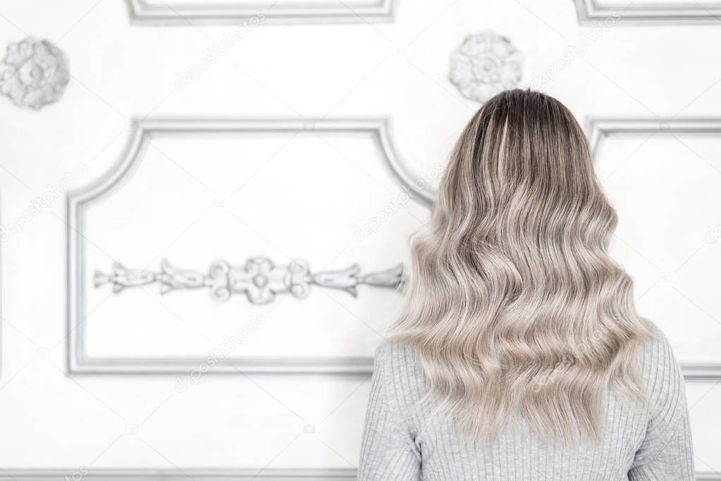 Back view of woman with beautiful blond ombre hairstyle standing in hair salon, Space for text