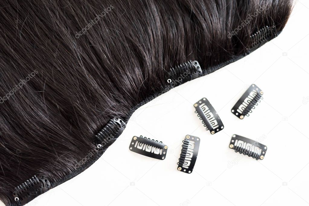 Black hair extension with clips isolated on white background, Equipment for hairstyle salon