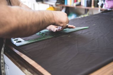 Dikiş makinesi ve kumaşı olan eski bir terzi atölyesi, sabun kalıplarıyla çiziyor.