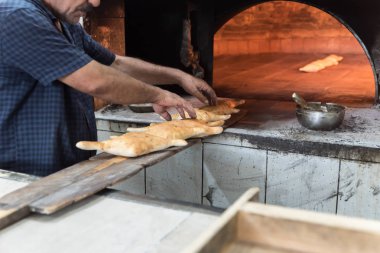 Fırının önünde eski bir fırıncı fırının kalitesini kontrol eder..