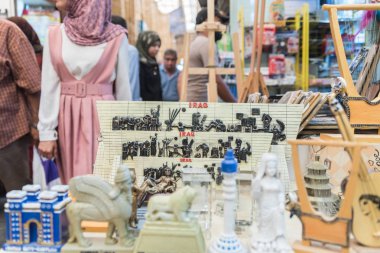 Irak, Bağdat - 6 Temmuz 2019: Şehir merkezindeki pazarda hediyelik eşya satan pazar. Arka planda ilginç ziyaretçiler.