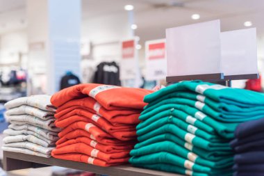 Alışveriş merkezinde gardırop mağazasında raflarda renkli tişörtler, alışveriş konsepti 