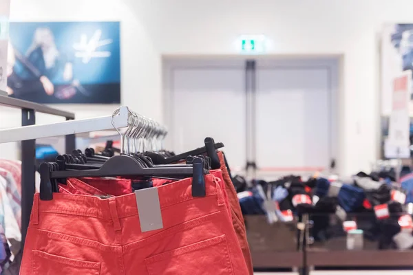 商场衣架上有红色裤子的服装店 购物理念 — 图库照片