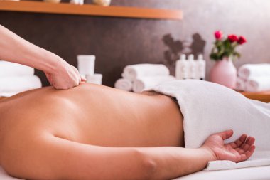 Kaplıca salonunda masaj yaptıran bir adam, yakın plan. Spor masajı