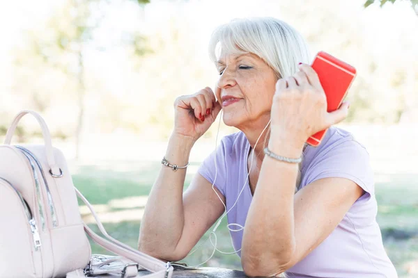 Femeie Vârstă Care Bucură Însorită Parc Ascultă Muzică Smartphone — Fotografie, imagine de stoc