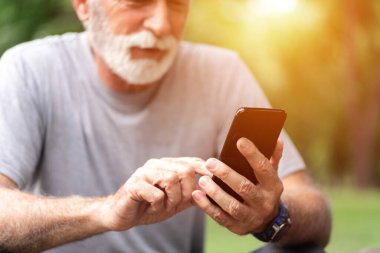 Parkta cep telefonu kullanan sporcu, sağlıklı yaşam tarzı kavramı